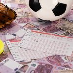 baseball glove and ball, soccer, tennis and rugby balls near betting lists on euro and dollar