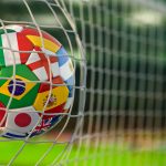 Football ball with flags of world countries in the net of goal o